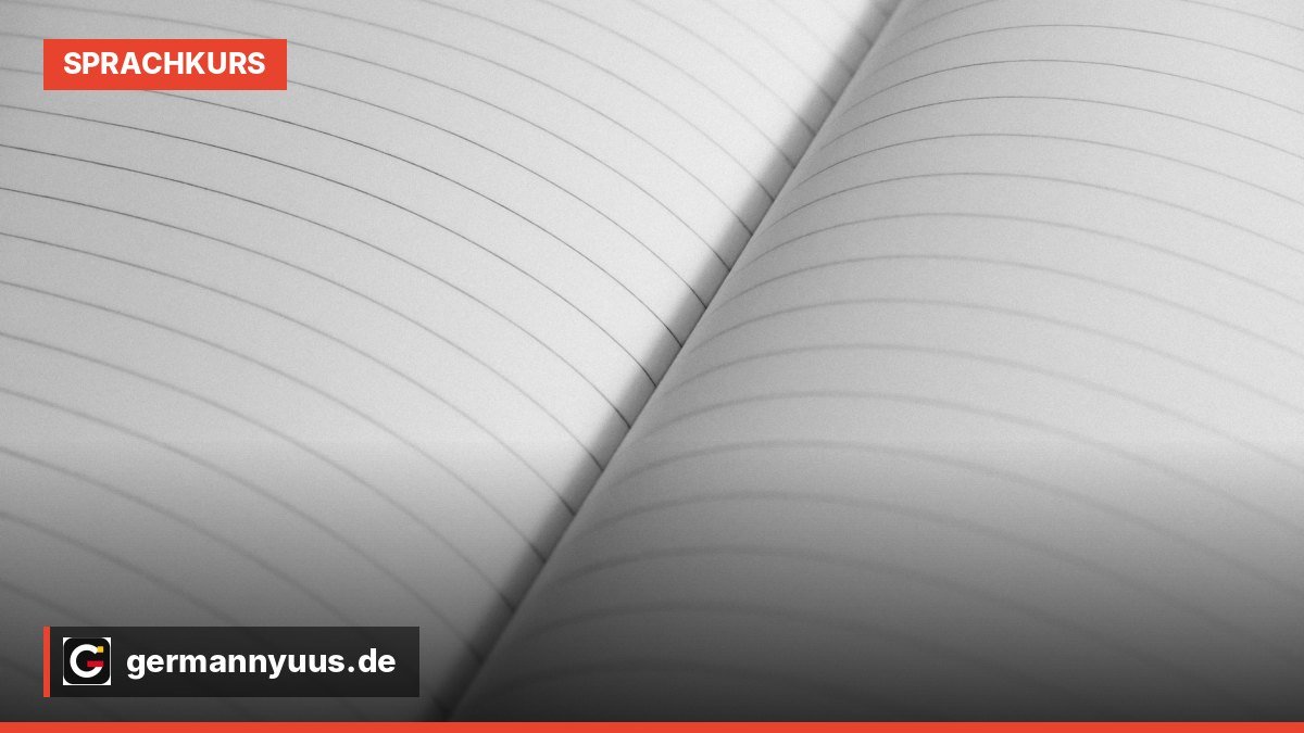 Ein aufgeschlagenes englisches Lehrbuch mit einem Notizblock und einem Stift auf einem Holztisch.