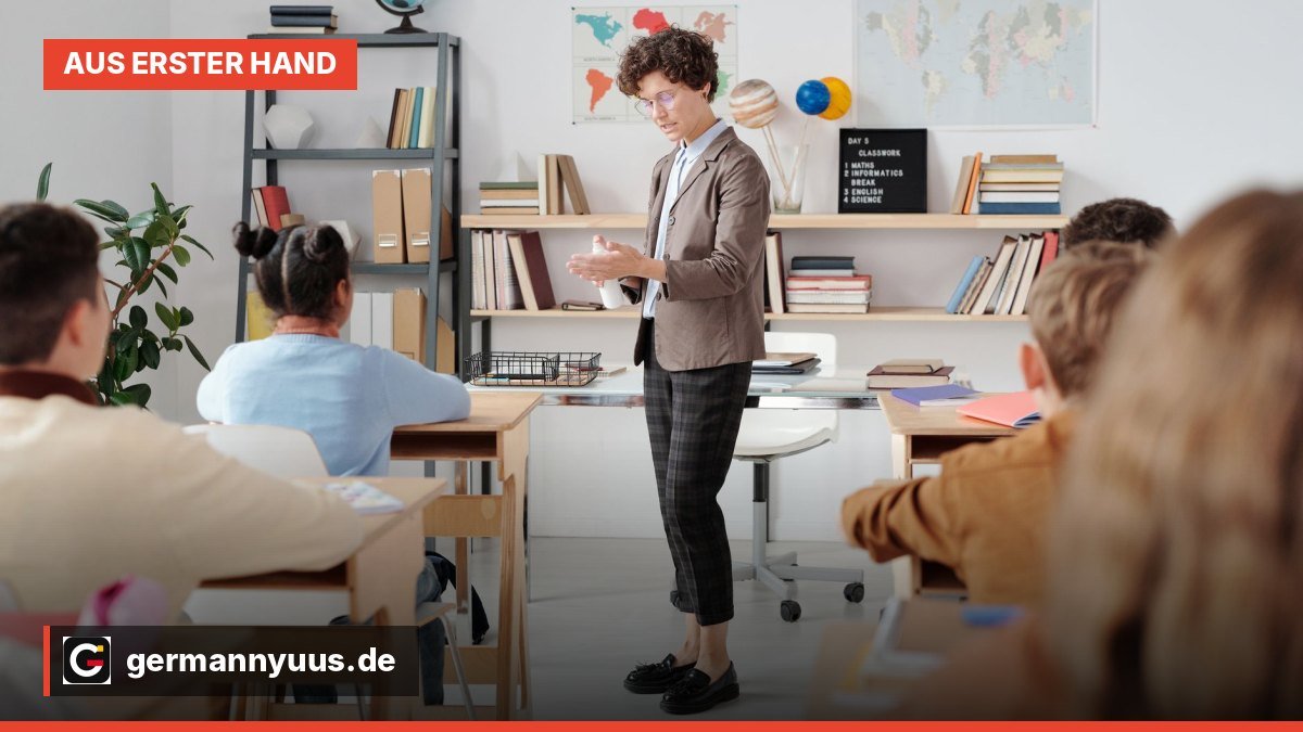 Eine Lehrerin schreibt an der Tafel in einem Klassenraum.
